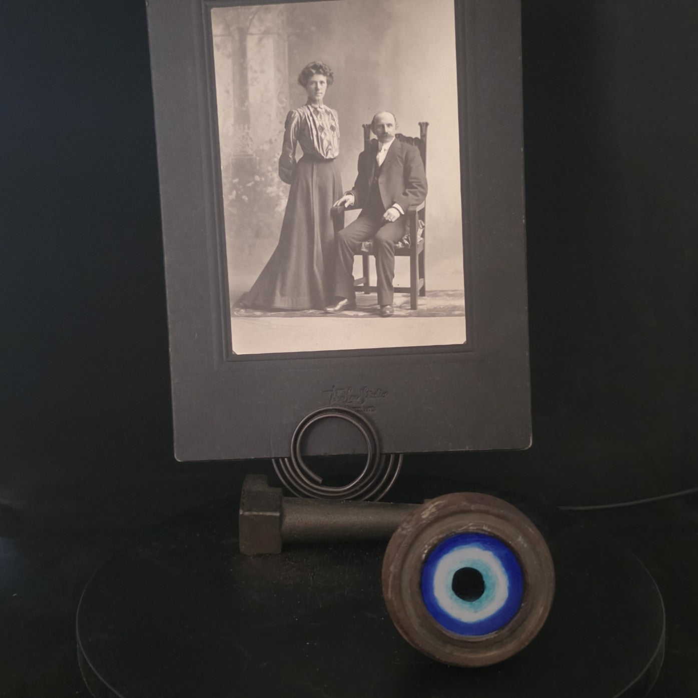Close-up of hand-painted Evil Eye symbol on vintage photo holder