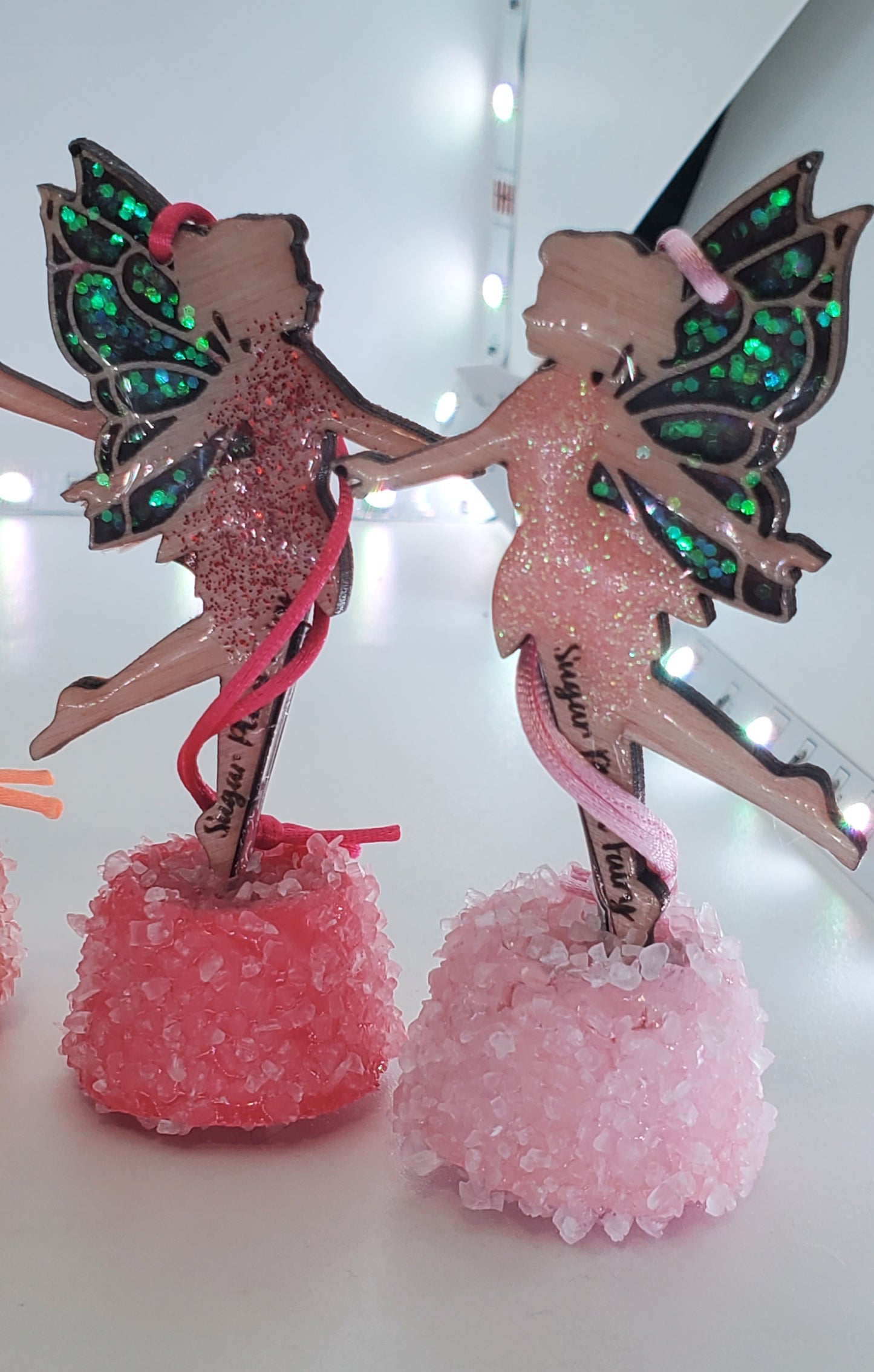 Decorative ornaments with a red and pink fairy design on a light white background