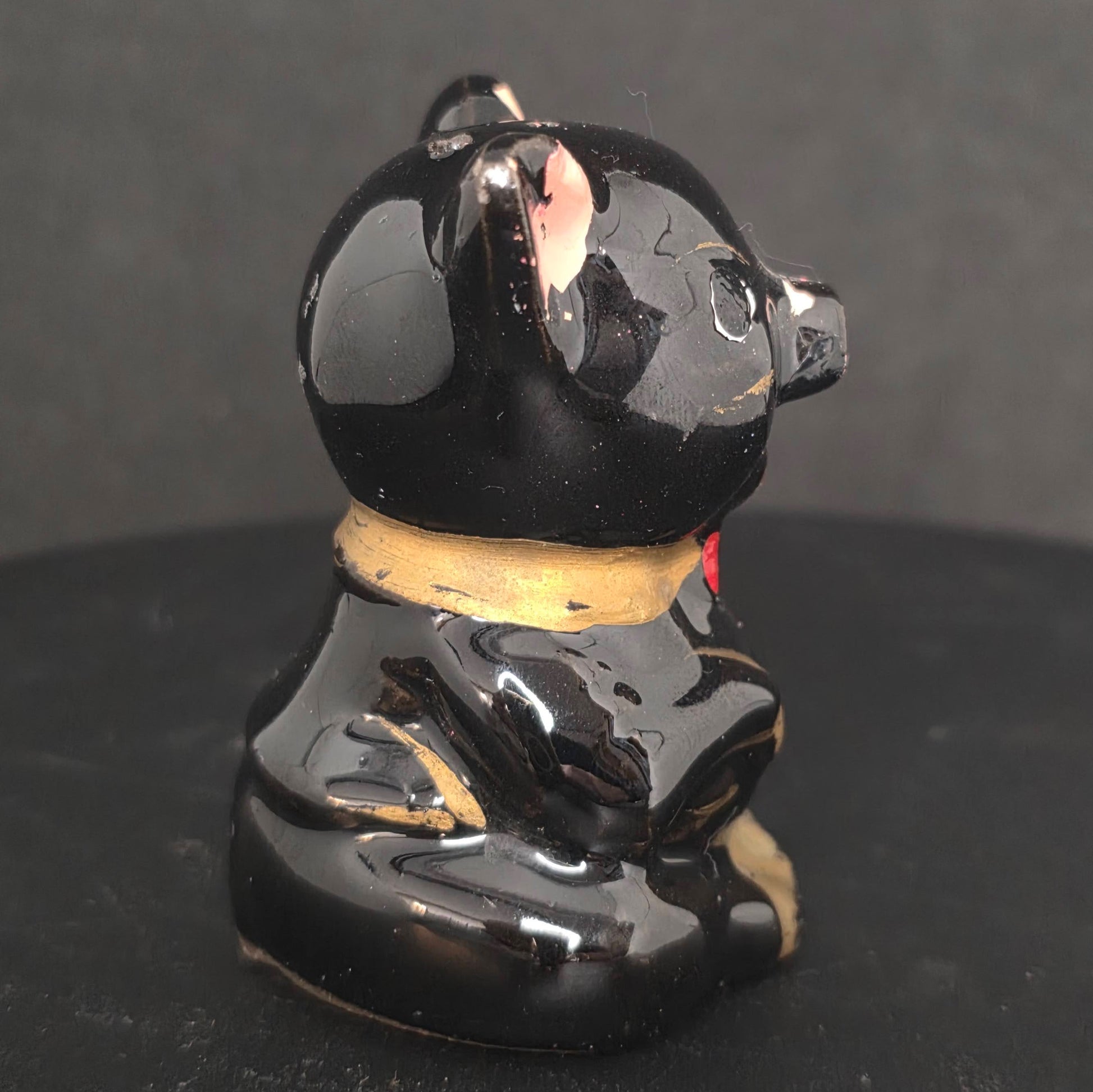 Side view of vintage black pig shaker with paint flaking