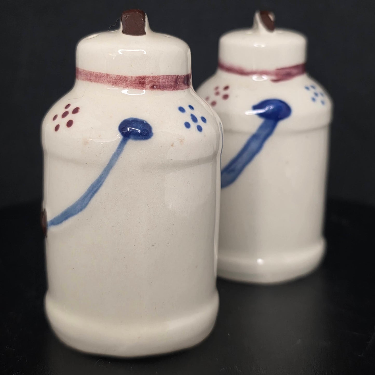 Side view of Shawnee Pottery milk can shakers, glazed ceramic