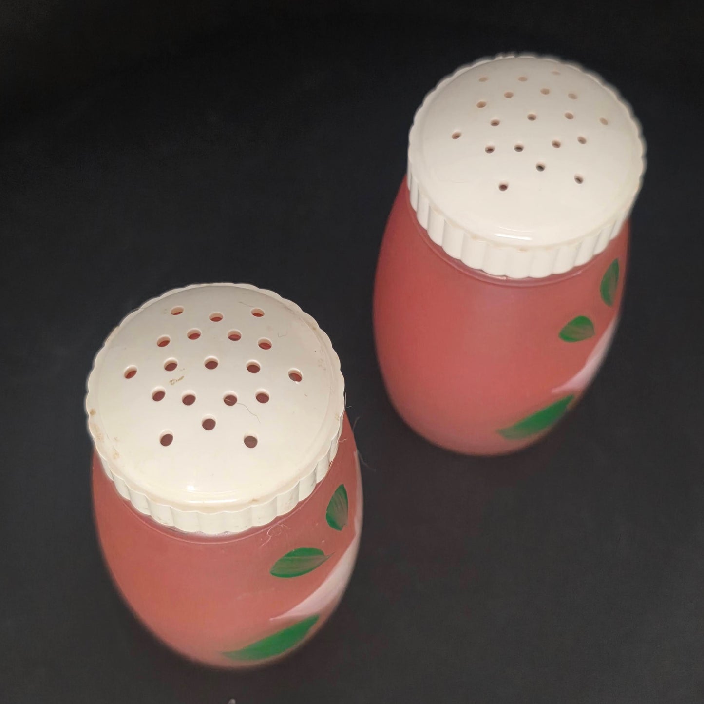 Close-up of Bartlett Collins pink frosted glass shaker plastic lids showing excellent condition with no yellowing or cracks