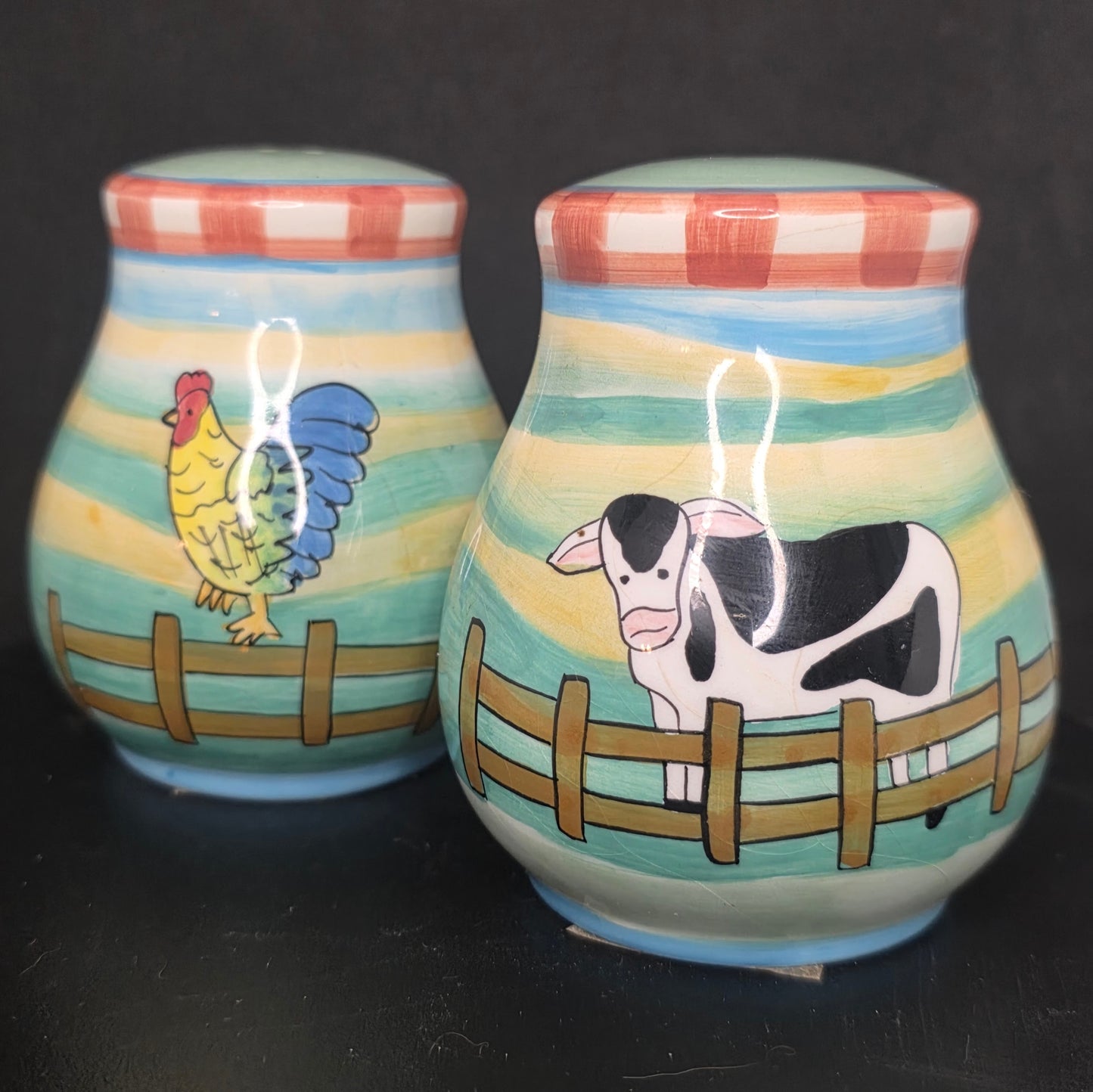 Front view of vibrant glazed ceramic cow and rooster shakers