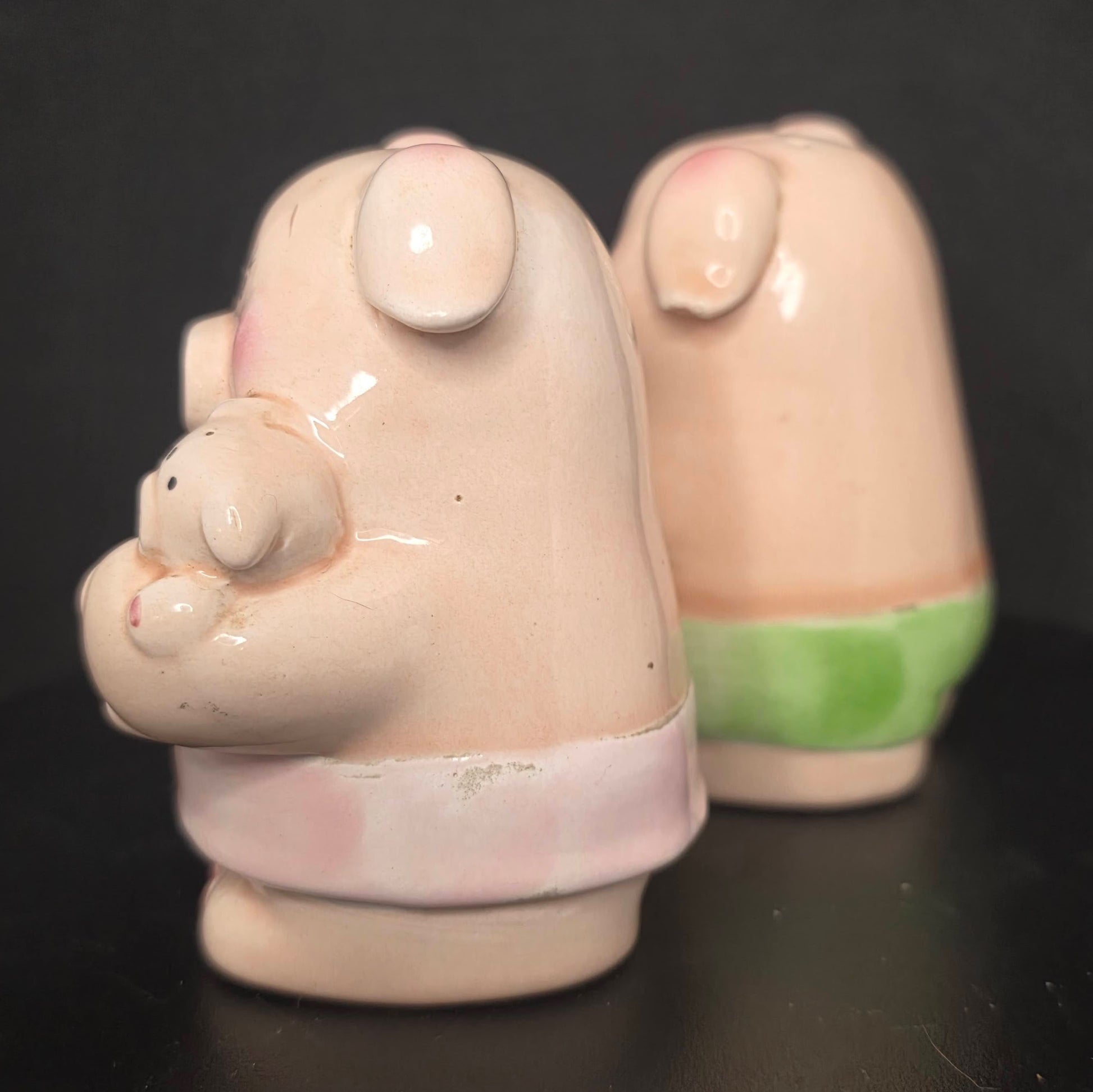 Side view of boy and girl pig shakers with stoppers, 3.25 inches tall