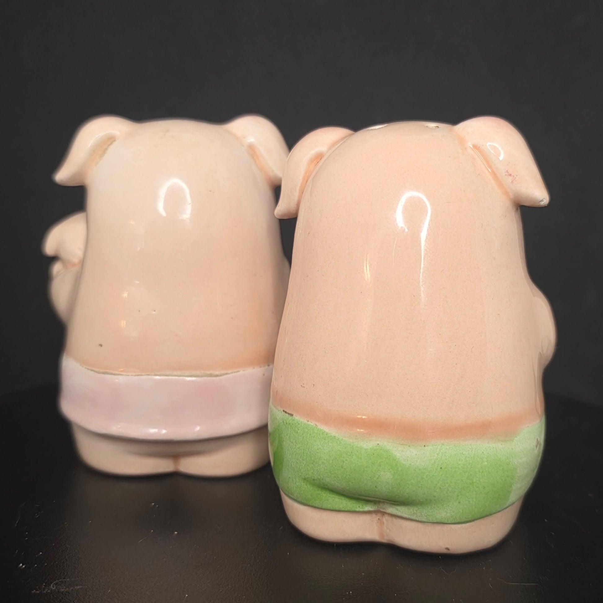 Back view of glazed ceramic pig shakers in excellent condition