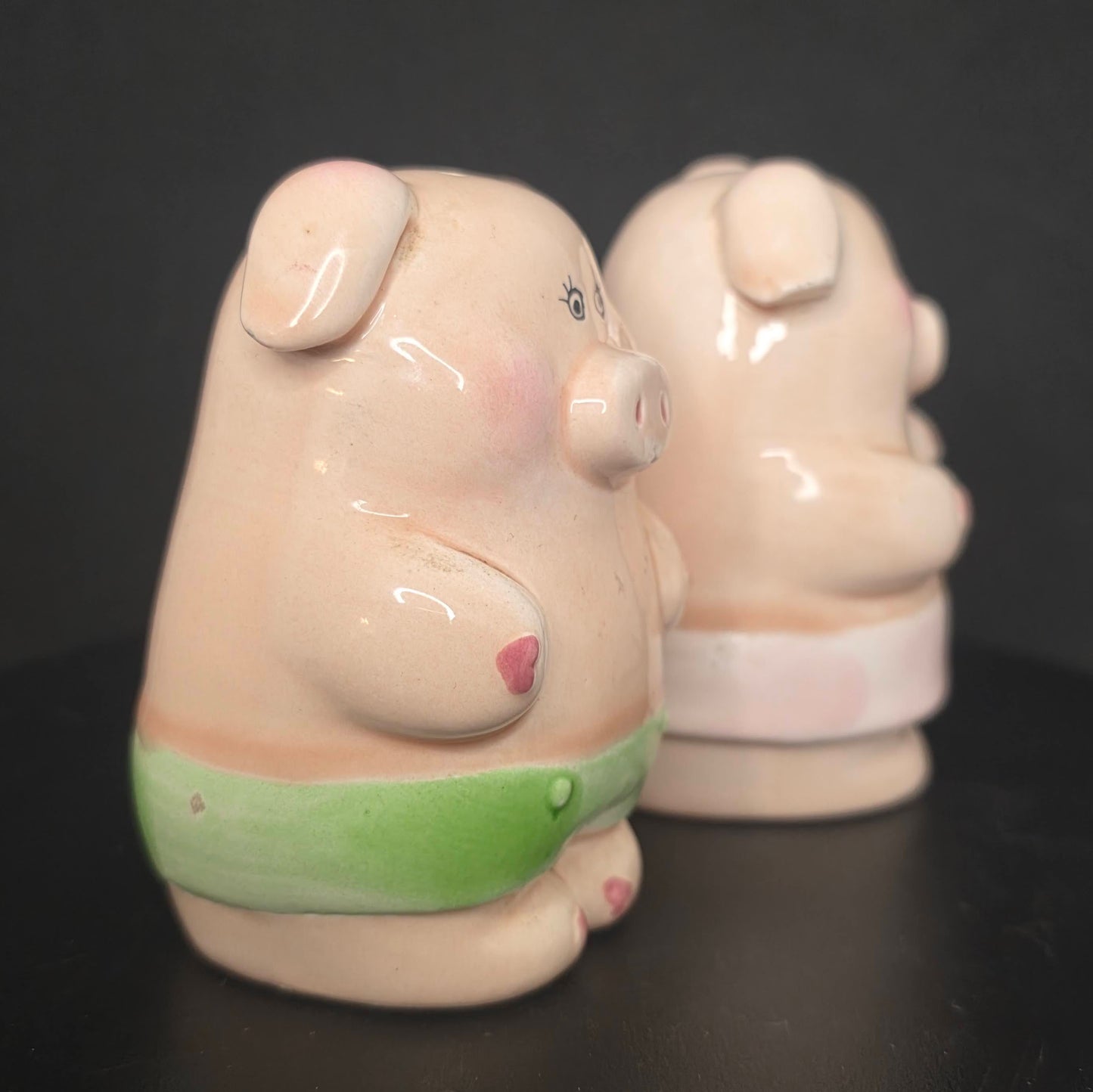 Side view of boy and girl pig shakers with stoppers, 3.25 inches tall