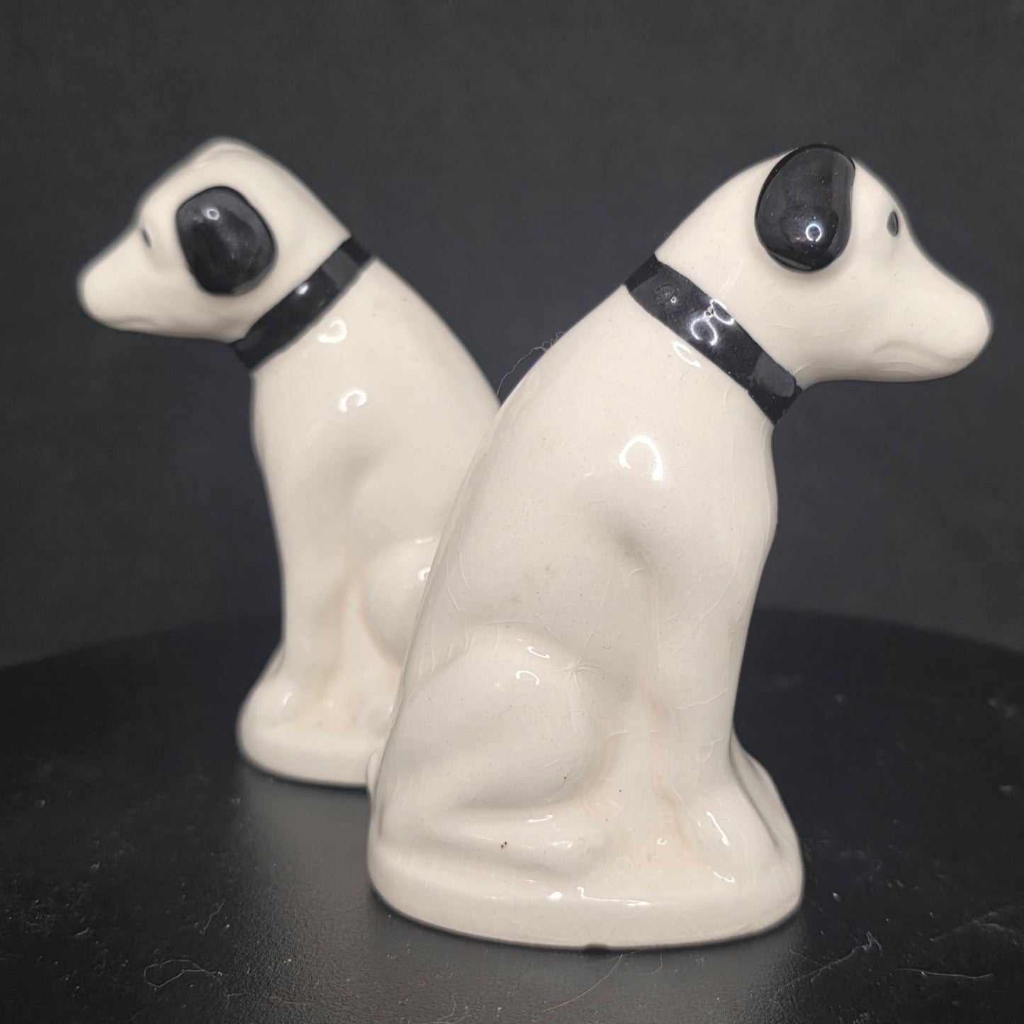 Side view of RCA Nipper dog shakers showing glazed ceramic finish
