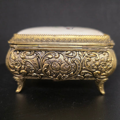 Vintage brass and enamel music box trinket box showing gold-tone finish and craftsmanship