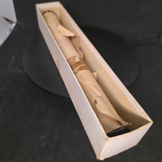 Vintage piano roll with unknown brand in damaged cardboard box showing extensive wear and brittle paper