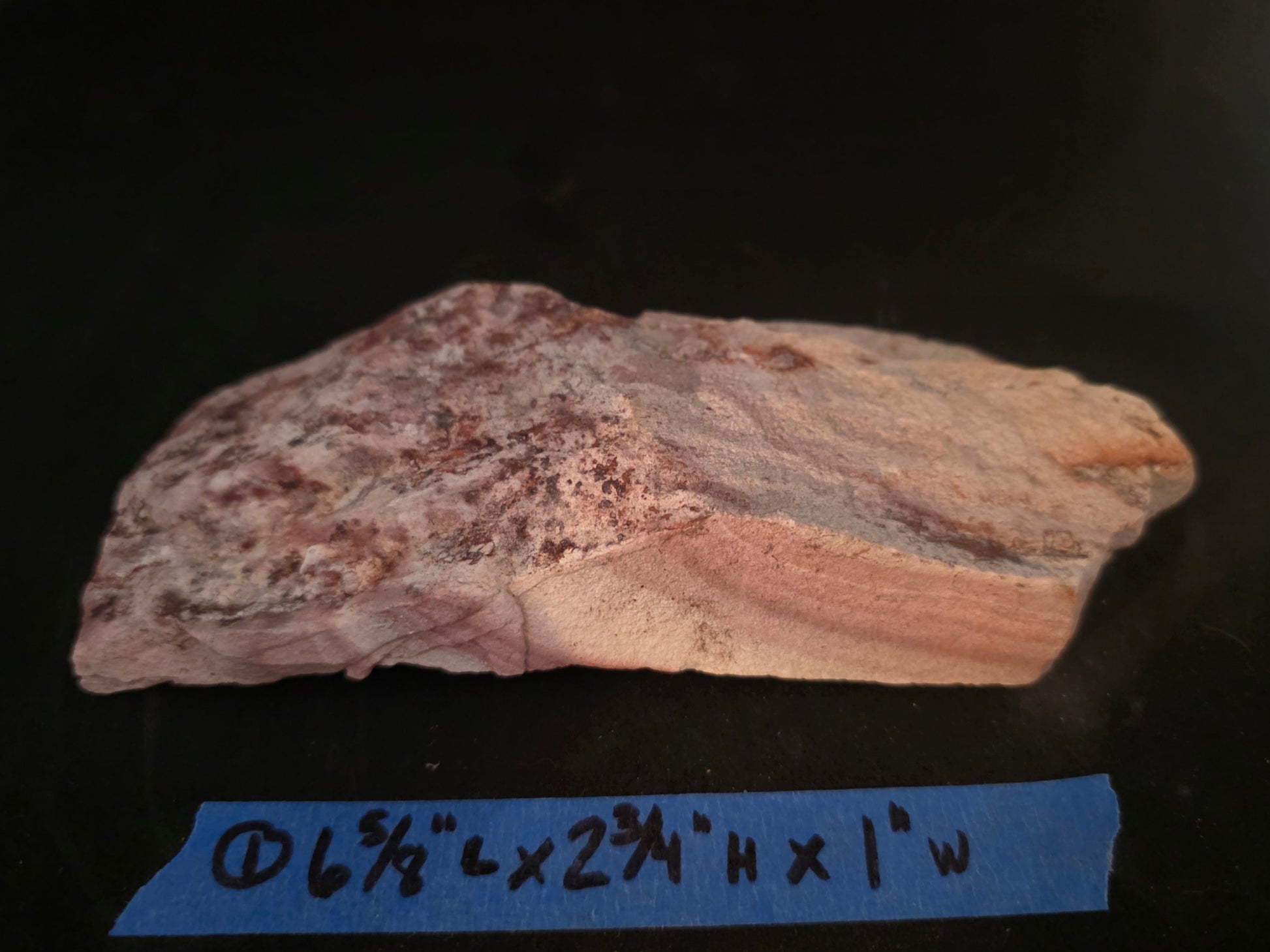 Geological sample with measurement label on a black background