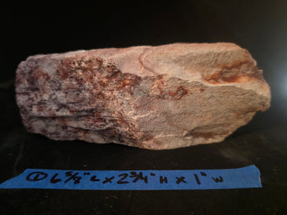 Rock sample with dimensions labeled on a dark background