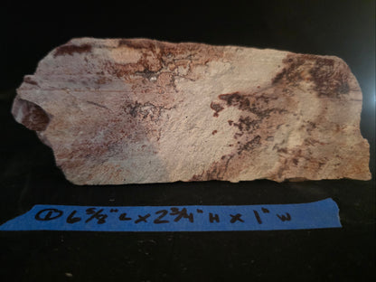 Brown rock or mineral sample with dimensions labeled on a dark background