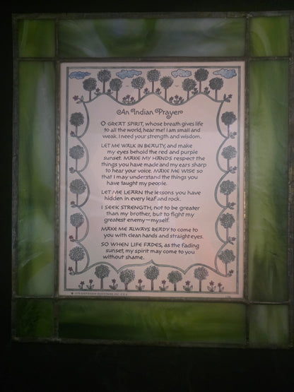 Decorative plaque with text and floral designs on a green stained glass background