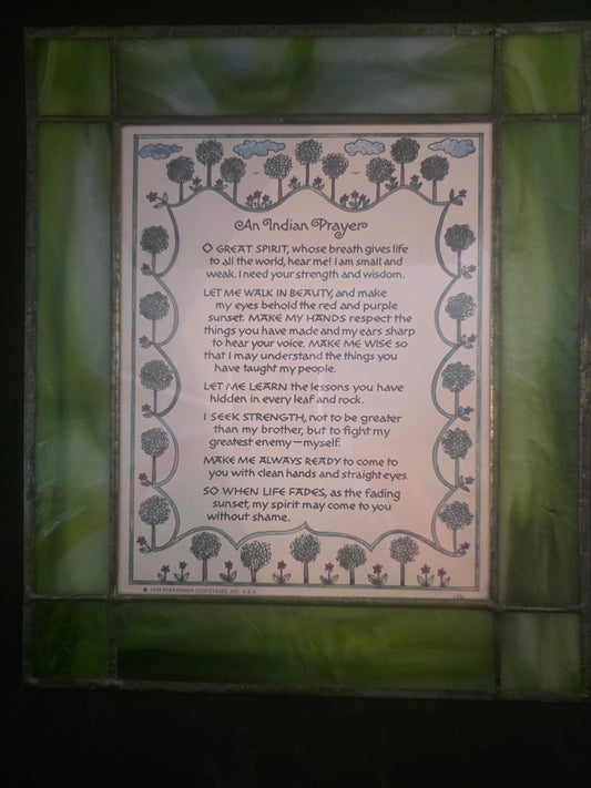 Decorative plaque with text and floral designs on a green stained glass background
