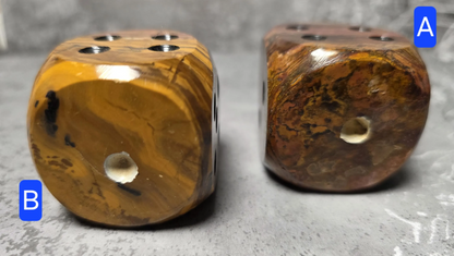 Two brown onyx dice with a textured surface on a gray background