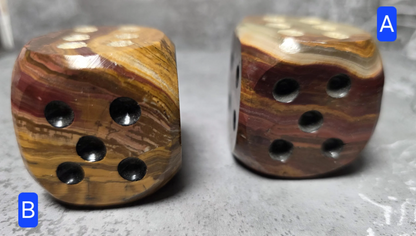 Two brown onyx dice with a textured surface on a gray background