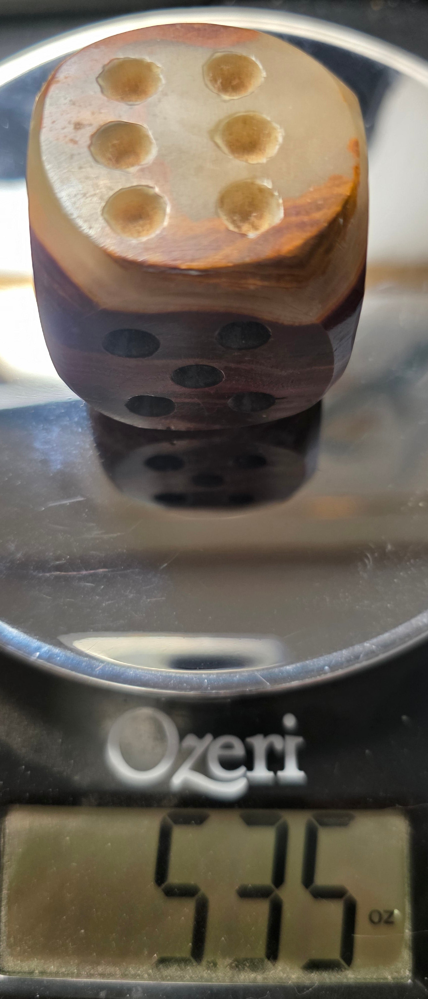 Onyx die with pips on a digital scale displaying weight