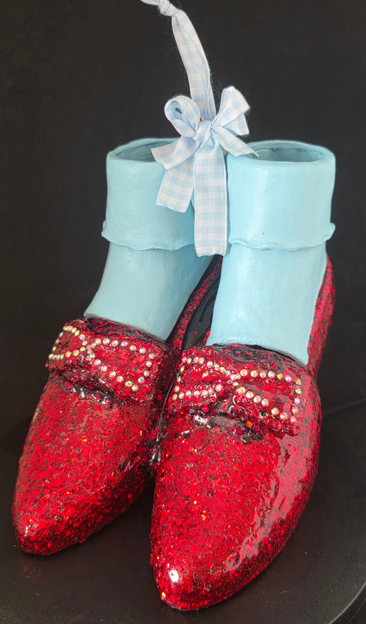 Wizard of Oz Ruby Slippers original mixed media art sculpture — glazed red ceramic shoes with glitter finish, rhinestone bow detail, and removable light blue polymer clay ankle socks, displayed as a standalone decorative piece